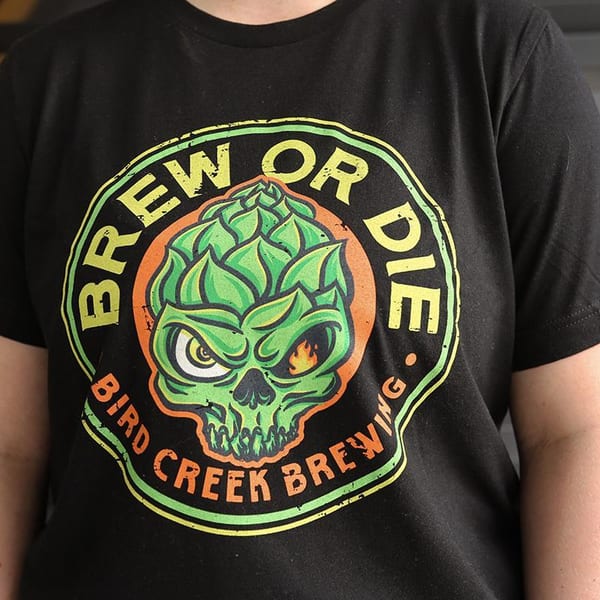 Person wearing a black t-shirt with a green hop skull logo and "Brew or Die" text.